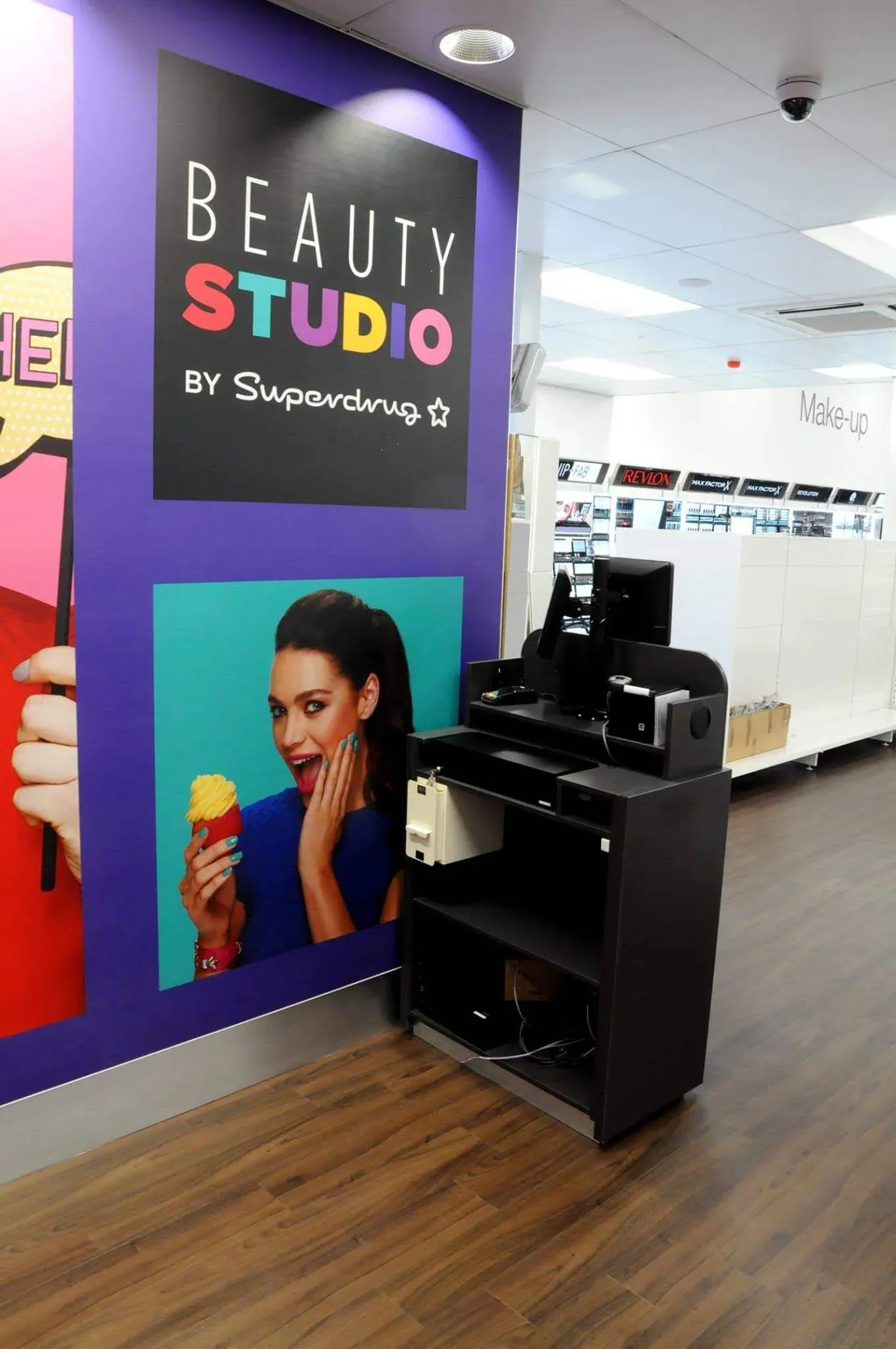 A completed Superdrug Beauty Studio with printed wall graphics and a black service counter