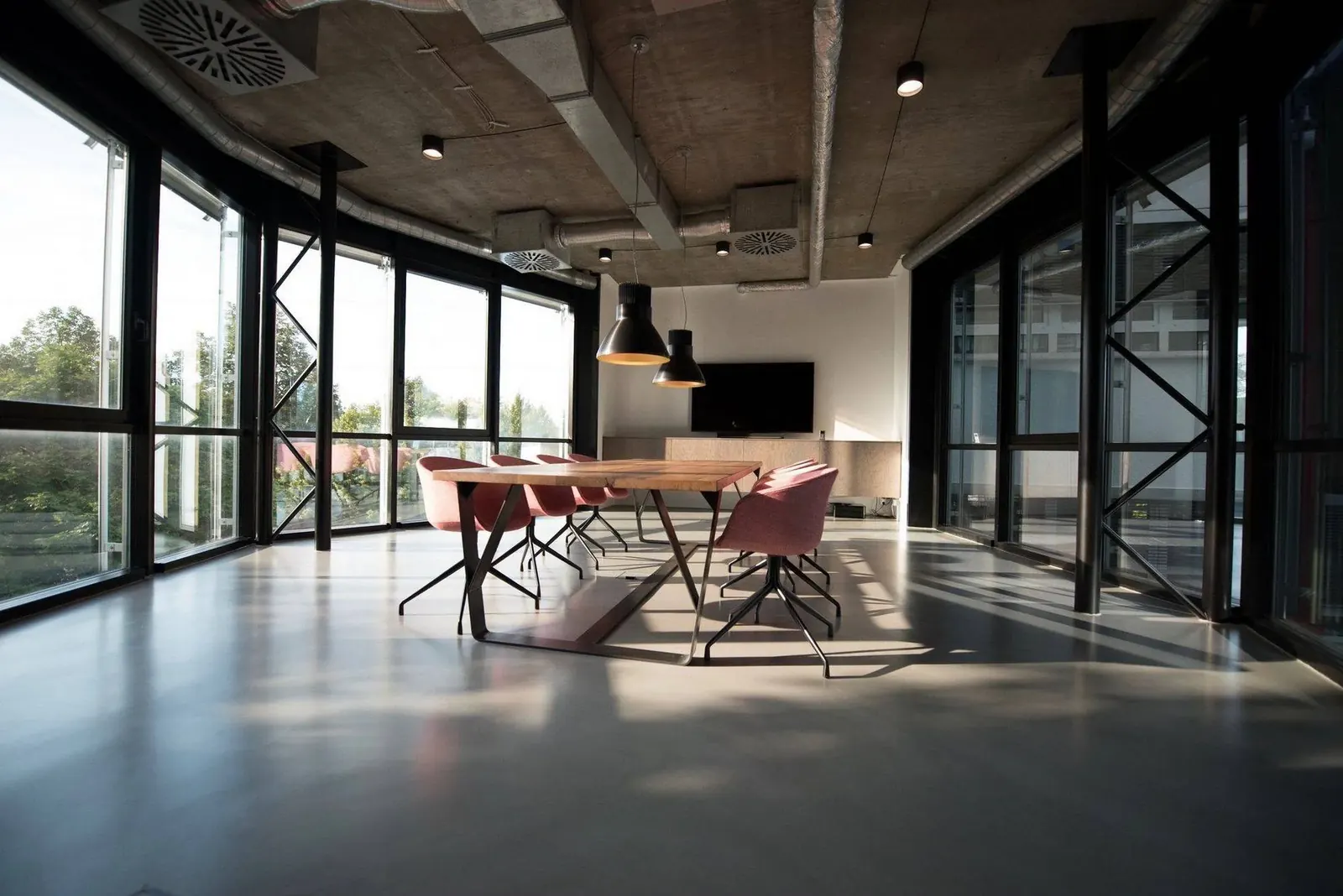 A finished open-plan space with floor to ceiling glazing and a long meeting table
