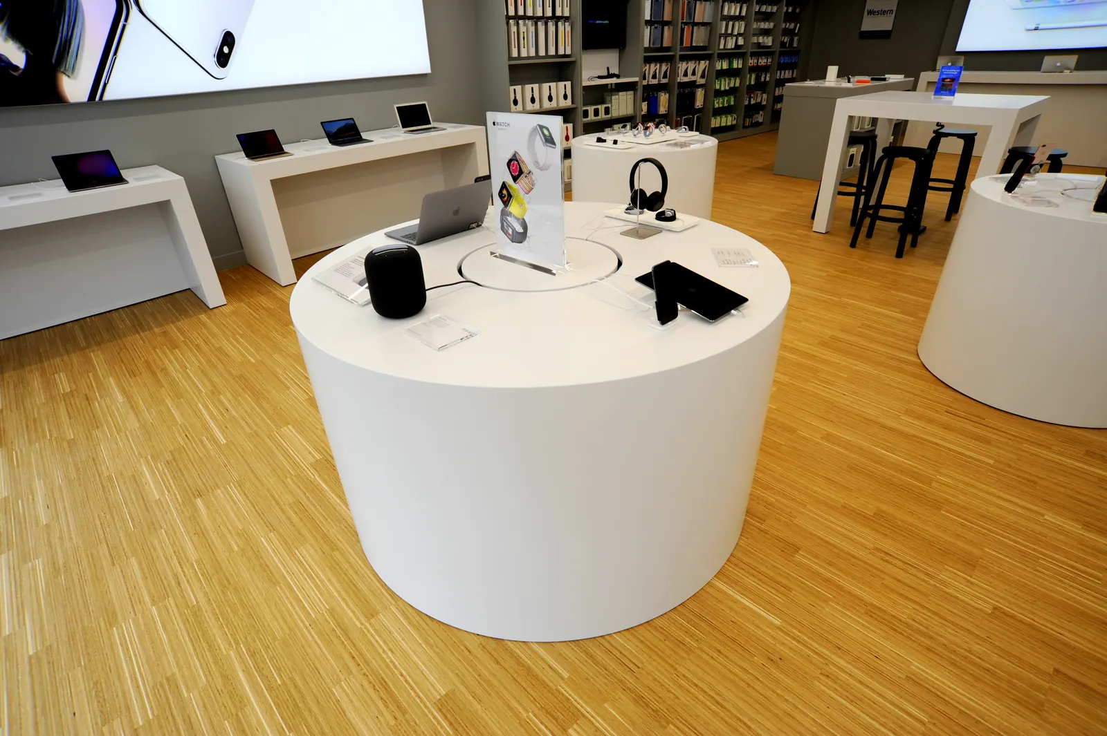 A round white display plinth with headphones and speakers