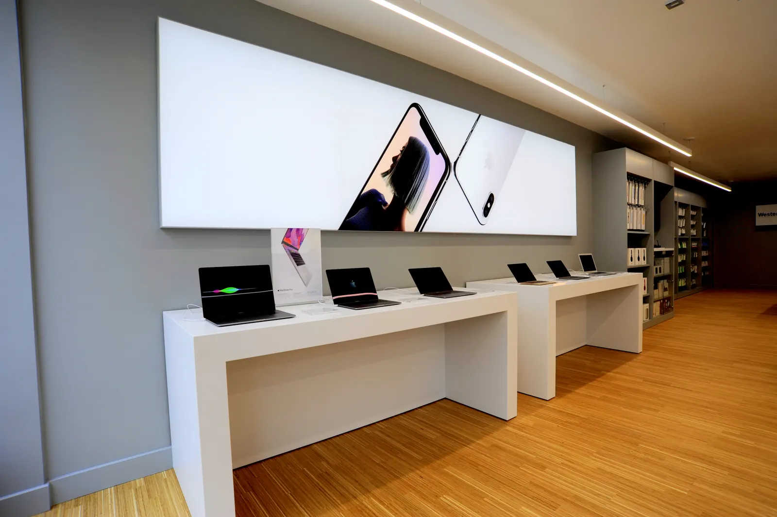 A row of laptop benches beneath a full-width lightbox